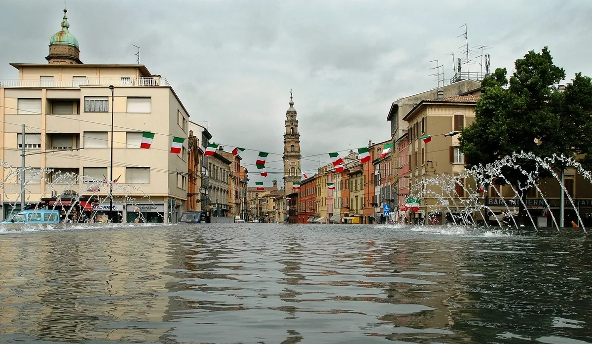 Strada della Repubblica seen from the Barriera Repubblica fountain, lined with flags