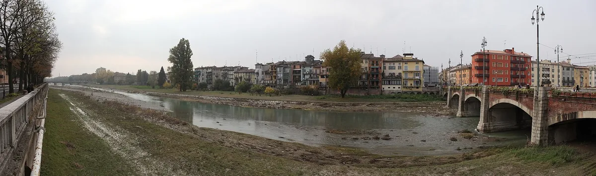 The Parma torrent's low-water bed with the arched Ponte di Mezzo and Oltretorrente houses