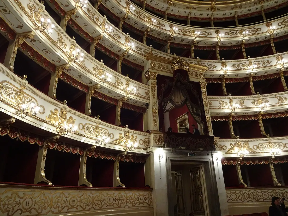 File di palchi dorati e crema intorno al palco reale all'interno del Teatro Regio di Parma