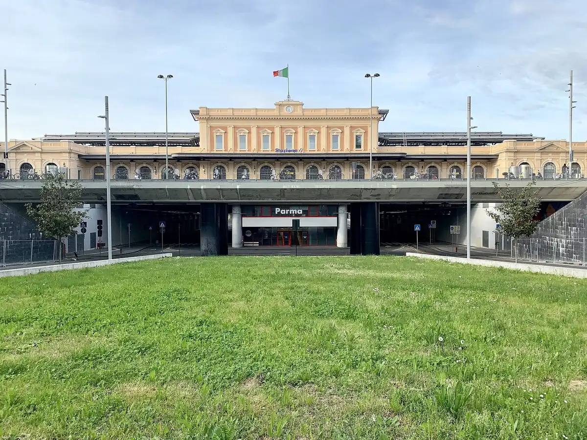 Parma railway station's restored facade above the modern underpass entrance
