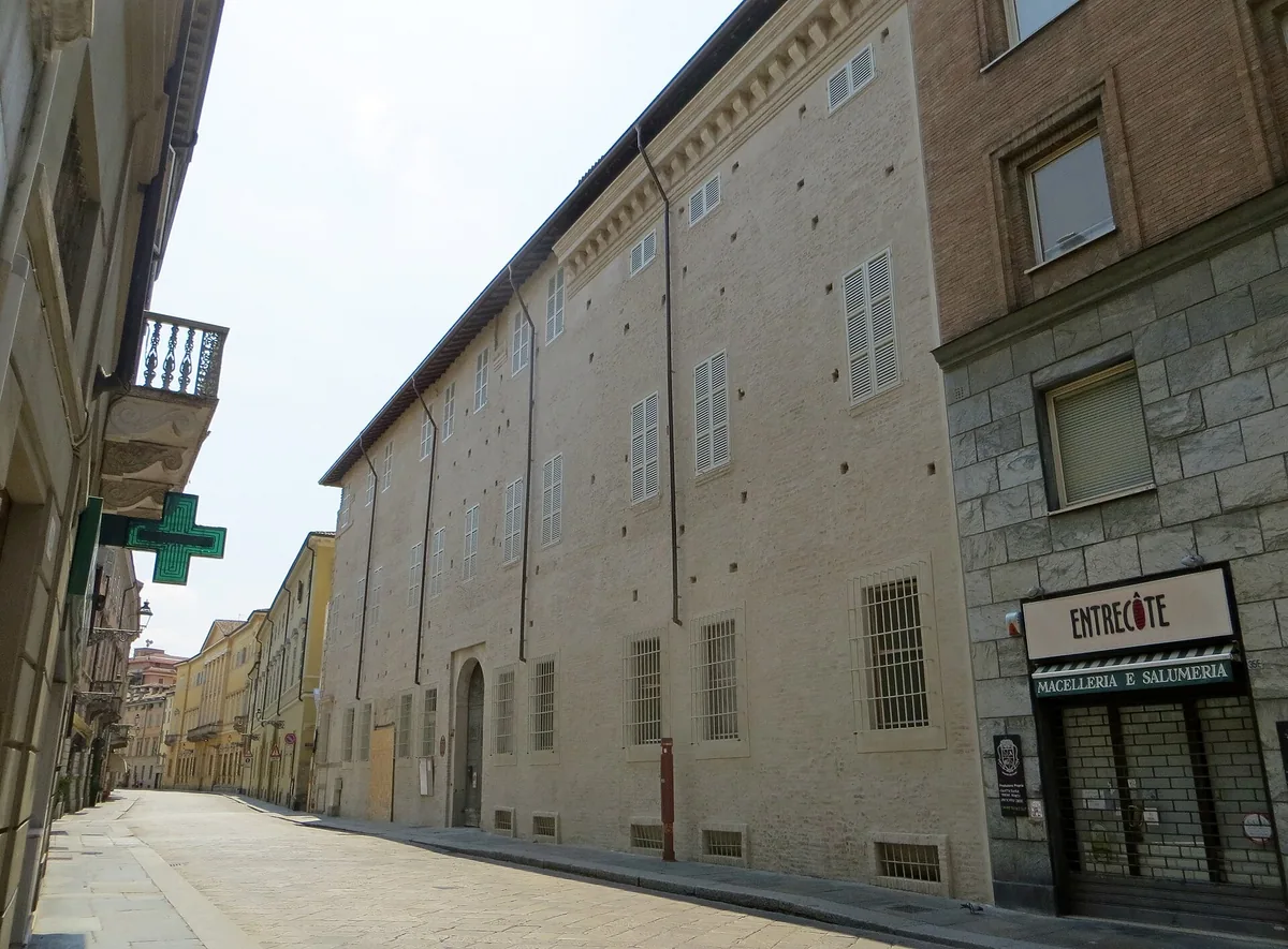 Strada Farini in Parma mit der langen Fassade des Palazzo Tarasconi und einem Salumeria-Schild