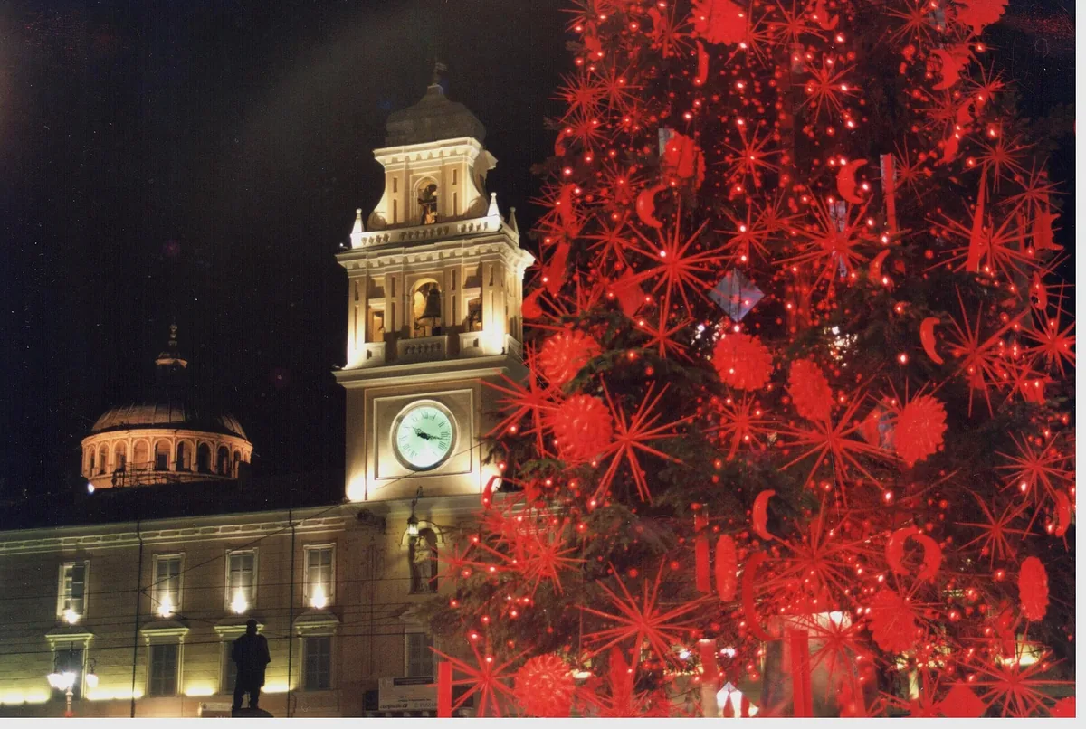 Weihnachtsbaum mit roten Sternlichtern neben dem beleuchteten Uhrturm auf der Piazza Garibaldi