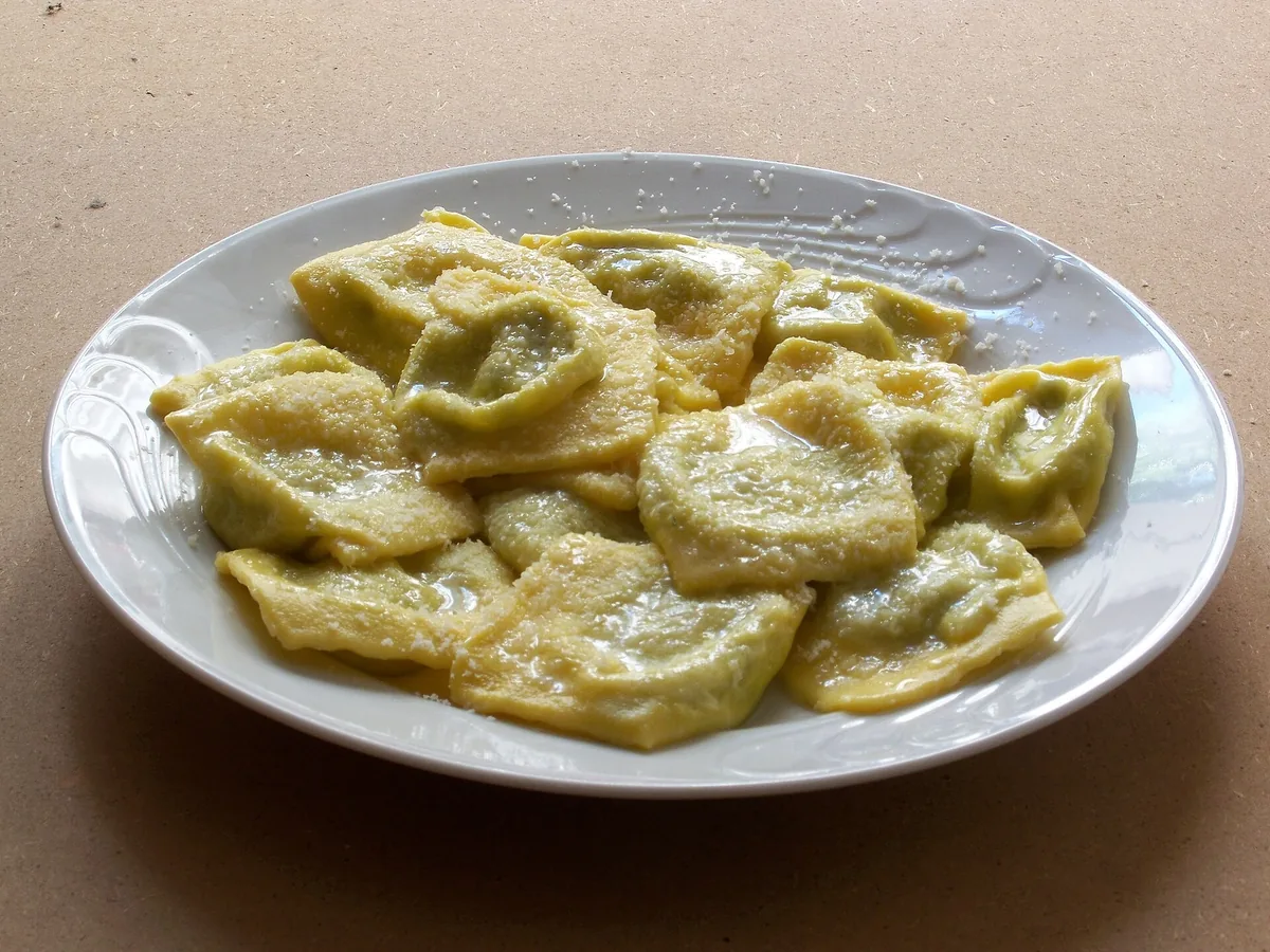 Teller mit tortelli d'erbetta, serviert mit Butter und Parmigiano