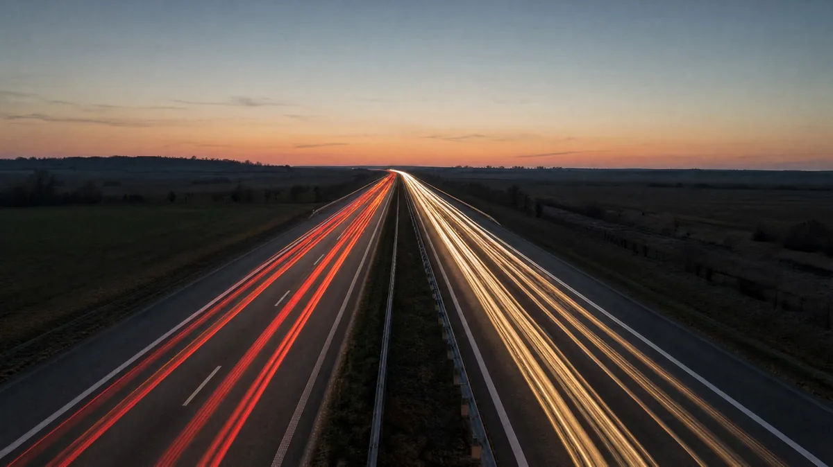 A motorway at dusk with light trails from passing cars