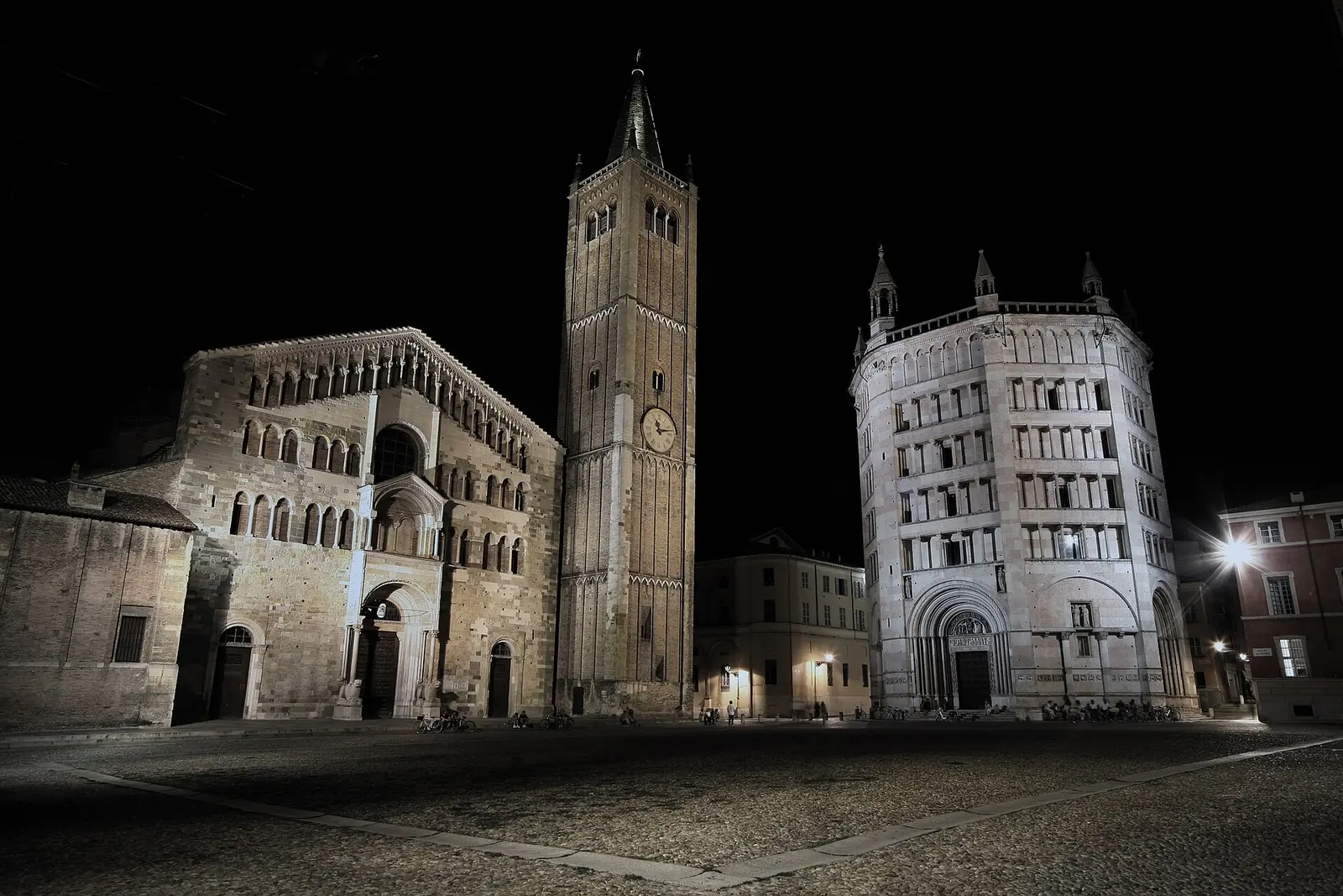 Dom von Parma, Glockenturm und Baptisterium bei Nacht beleuchtet auf der leeren Piazza Duomo