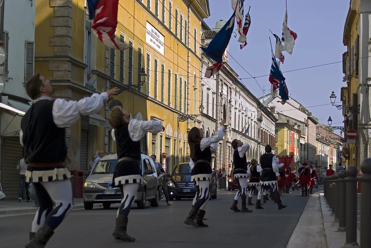 Flag-throwers in costume parading down Strada Massimo D'Azeglio in Parma