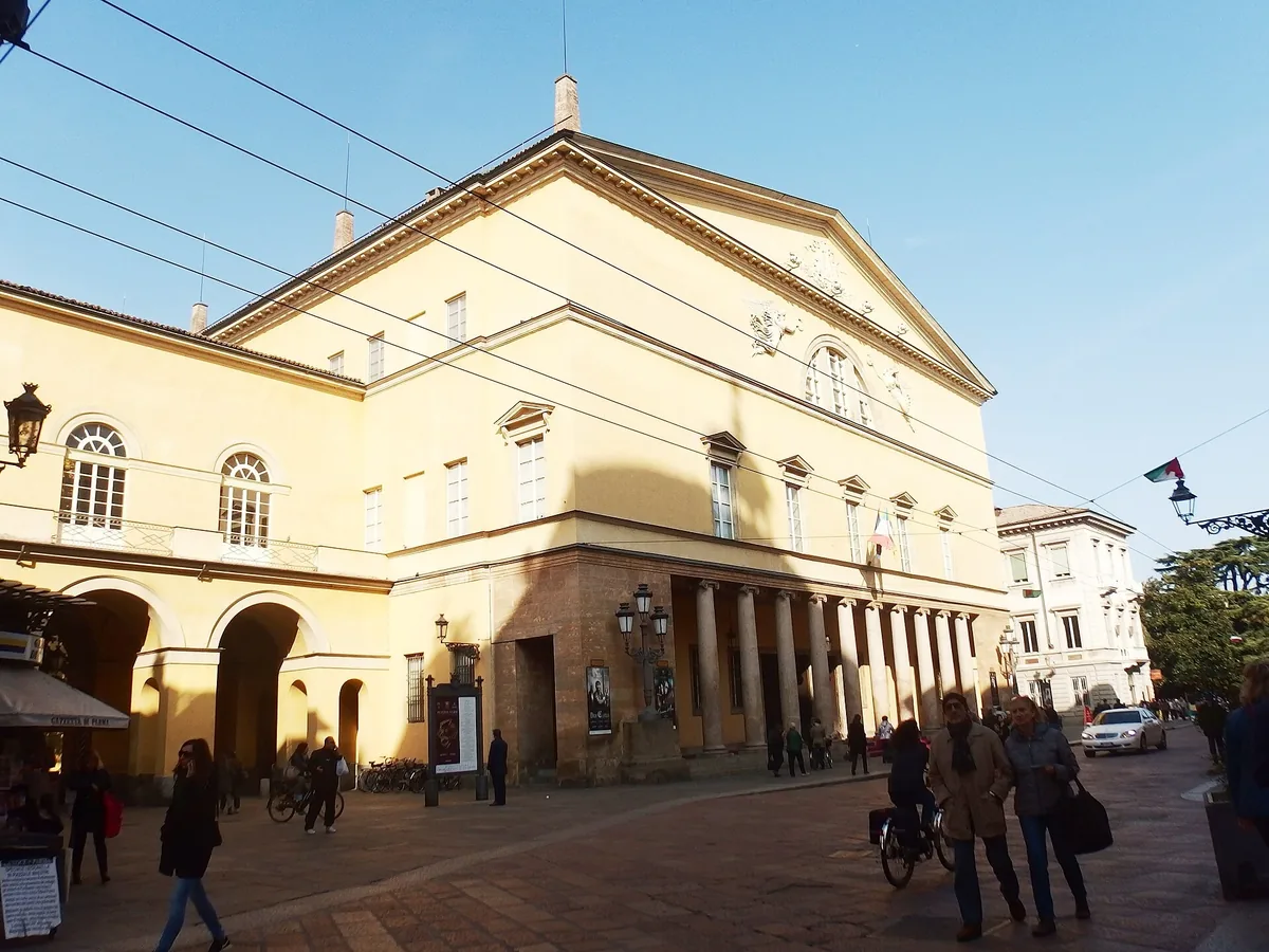 Neoclassical facade and colonnaded portico of the Teatro Regio di Parma in late sun