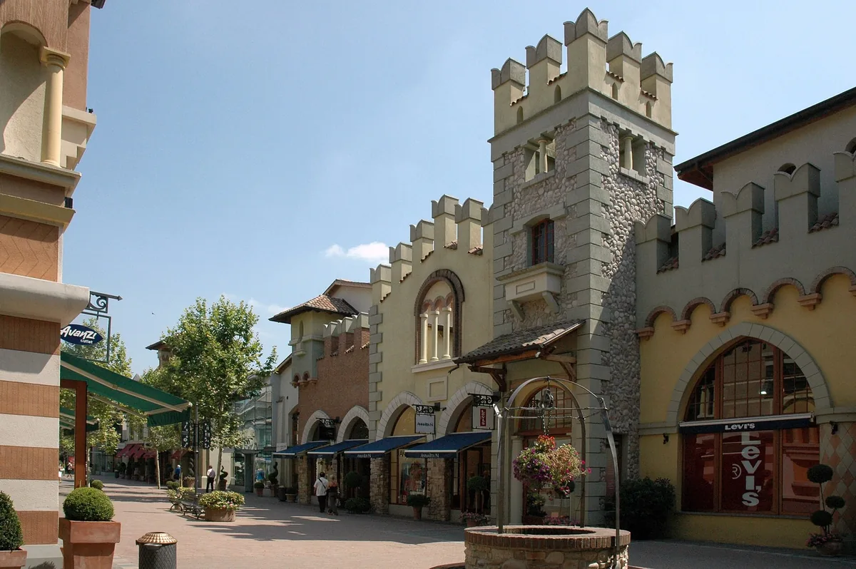 Shop facades and a mock crenellated tower in the Fidenza Village outlet centre