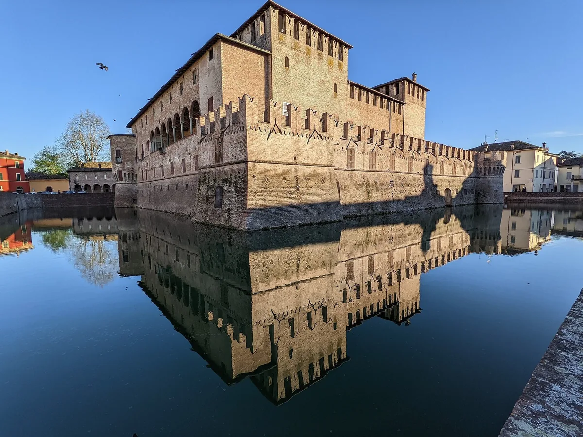 Rocca Sanvitale in Fontanellato, die sich im Burggraben spiegelt unter klarem Himmel